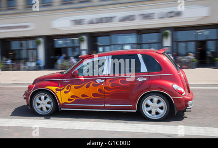 Malte Flammen auf Autos. Custom Car, Straße Stangen und Hot Rods mit Flaming Wheels, and blacked out Windows auf einem beweglichen Angepasste rot Chrysler Cruiser, Blackpool, Lancashire, Großbritannien Stockfoto