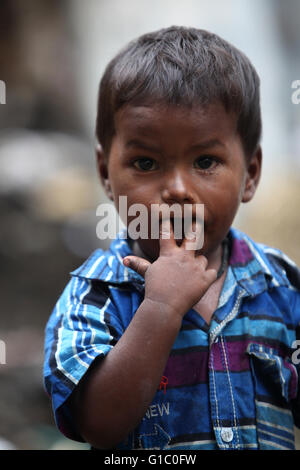 Pune, Indien - 16. Juli 2015: Ein Portrait eines armen indischen jungen er Finger in den Mund. Stockfoto