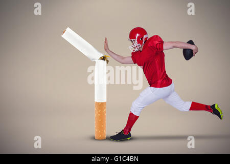 Zusammengesetztes Bild des american Footballspieler mit dem Ball springen Stockfoto