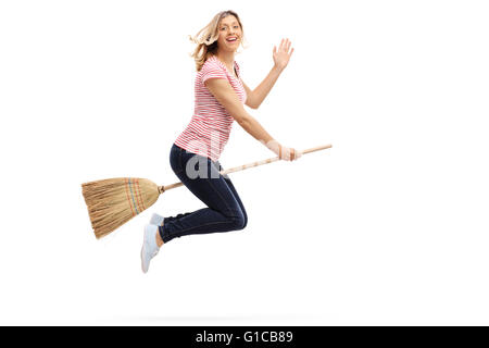 Frau auf einem Besen fliegen und winkte mit der Hand in Richtung der Kamera isoliert auf weißem Hintergrund Stockfoto