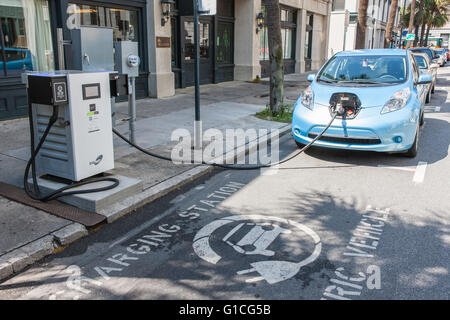 Ein Elektroauto Nissan Leaf wird eine Gebühr von einem öffentlichen SigNet Ladestation auf Bull Street in Savannah, Georgia. Stockfoto