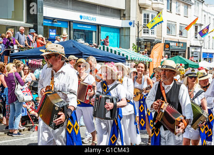 Familien, Schulen und Freunde marschieren durch die Straßen von Penzance in Cornwall am Mazey Tag Teil des Golowan festival Stockfoto