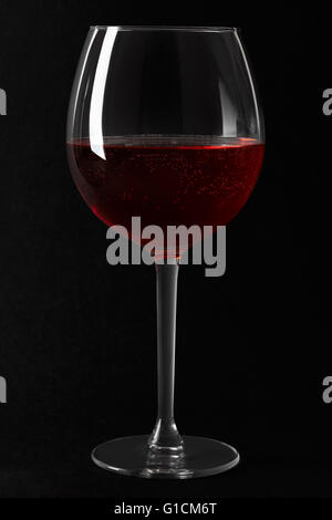 Roter Sekt Glas auf schwarzem Hintergrund Stockfoto