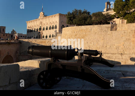 Kanonen auf den Wällen von St. Peter und Paul Counter-Guard und die barocke Fassade der Auberge de Castille im Hintergrund. Stockfoto