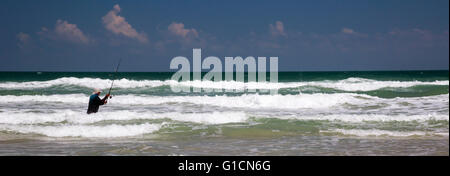 Titusville, Florida - ein Fischer in den Atlantischen Ozean Wellen im Canaveral National Seashore. Stockfoto