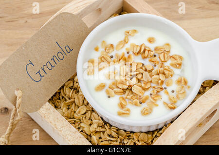 Frühstück-Hafer-Müsli mit Joghurt in eine Schüssel weiß auf Holztisch. Stockfoto