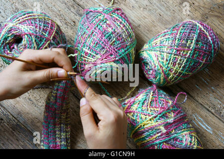 Frauen die hand stricken Wolle Handschuh zu Weihnachten ein besonderes Geschenk für den kalten Winter, bunte Wolle ball Stockfoto