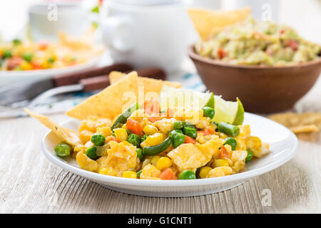 Hausgemachte mexikanischer Salat Rührei serviert mit Mais-Tortilla-Chips und Guacamole, gesundes Frühstück Stockfoto