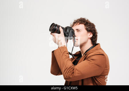 Junger Mann bei professionellen Kamera isoliert auf weißem Hintergrund fotografiert Stockfoto