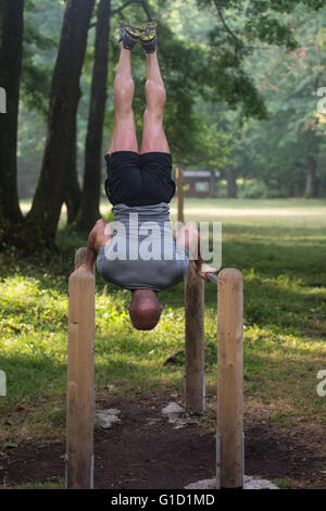 Sportler trainieren Hand Stand parallel Bars In eine Turnhalle im freien - Doing Street Workout Übungen Stockfoto