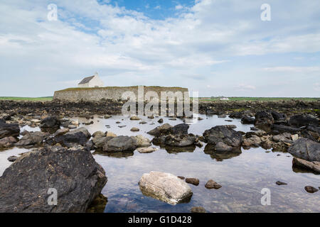 Die dramatische Kirche St Cwyfan auf Ynys Mon (Anglesey) Wales Stockfoto