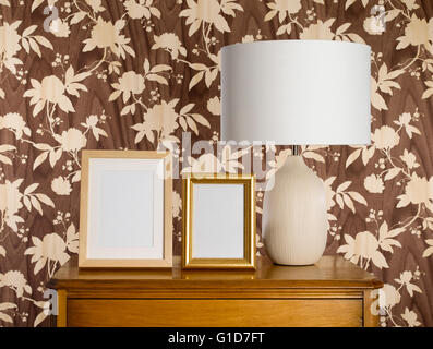 Lampenschirm auf Sideboard mit leeren Bilderrahmen Stockfoto
