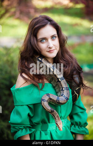 Porträt der attraktive Teenager-Mädchen mit Schlange in einem Garten Stockfoto