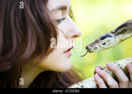 Attraktive Teenager-Mädchen halten die Python in der Nähe in der Nähe des Gesichts Stockfoto