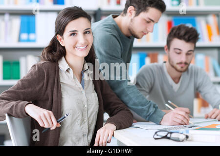 Gruppe von College-Studenten lächelnd gemeinsam in der Bibliothek studieren und arbeiten an einem Projekt Stockfoto