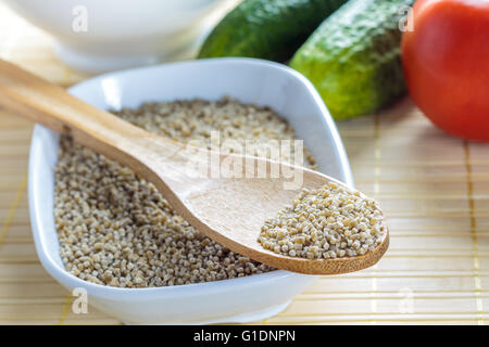 Ungekocht Buchweizen-Nudeln für Tarhana Suppe mit Tomaten, Gurken und weiße Schale im Hintergrund Stockfoto