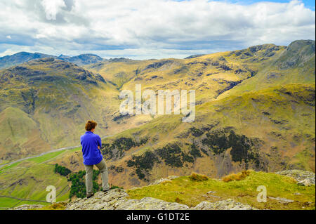 Walker auf Hecht o'Stickle eines Langdale Pikes im Lake District, mit Blick auf die Coniston Fells und Crinkle Crags Stockfoto