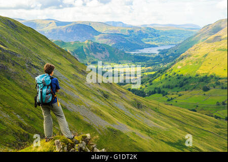 Walker mit Blick auf Hartsop Tal von oben Raven Klippe Threshthwaite im Lake District, mit Ullswater in der Ferne Stockfoto