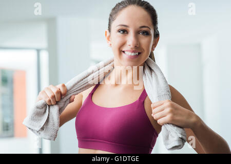 Schöne sportliche Frau mit Handtuch entspannen, im Fitnessstudio trainieren, gesunde Lebensweise und Fitness-Konzept Stockfoto