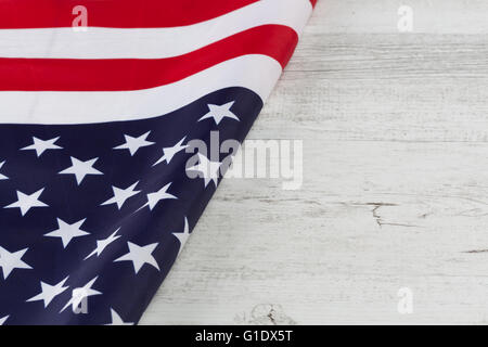 Amerikanische Flagge diagonal gefaltet auf weißem rustikalen Holztisch. Horizontales Bild mit Textfreiraum Stockfoto