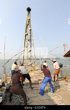 FORT KOCHI, Indien - 16. Januar 2015: Fischer betreiben eines chinesischen Fischernetz basierend auf Alter Technologie und traditioneller Materia Stockfoto