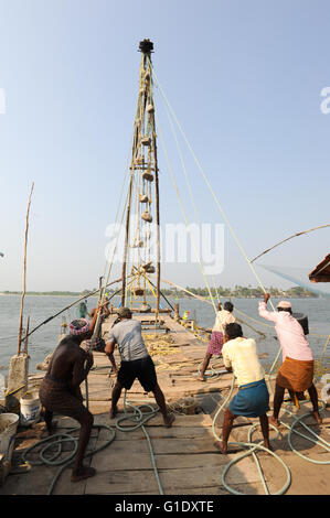 FORT KOCHI, Indien - 16. Januar 2015: Fischer betreiben eines chinesischen Fischernetz basierend auf Alter Technologie und traditioneller Materia Stockfoto