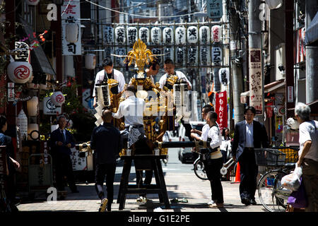 TOKYO, JAPAN - Mai 13: Traditionell gekleideter Teilnehmer an Sanja Matsuri bereitet ihre Mikoshi in Asakusa, Tokio, Freitag Morgen des 13. Mai 2016. Sanja Matsuri, das größte von Tokios traditionellen "drei große Feste". Held im Asakusa-Schrein, ein dreitägiges Wochenende des ungestümen traditionelle Mikoshi (tragbarer Schrein) Prozessionen durch die Straßen von Asakusa, mit viel trinken, tanzen, Musik und andere lebendige Spaß. Organisiert von der Senso-Ji-Tempel in Tokio, über 2 Millionen Menschen Festivalbesucher zieht in den Straßen. Gold und Schwarz Lack Mikoshi sind die Fahrzeuge der Stockfoto