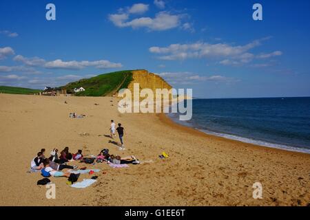 West Bay, Dorset, UK. 14. Mai 2016. Junge Menschen entspannen Sie am West Bay Beach nach einem heißen sonnigen Nachmittag auf Dorset Jurassic Coast. Bildnachweis: Tom Corban/Alamy Live-Nachrichten Stockfoto