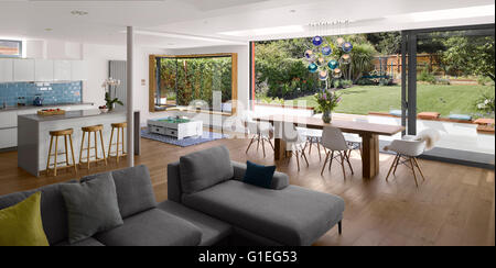 Eingeschossige Erweiterung, Mincheon Road, London. Offenen Wohnraum und Küche. Modernen Möbeln und Blick auf den Innenhof und Garten. Große Glas-Schiebetüren. Stockfoto