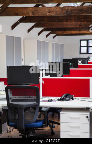 Umgebaute Scheune in Büroräume. Möbel von OEG-Interieurs. Zeilen der Büroschreibtische mit Computern und rote Tafeln. Stockfoto