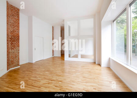 Buro, 53 Reichenberger Straße. Geräumiges Zimmer mit modernem Layout und Backstein-Mauer. Große Fenster und Glaswand. Stockfoto