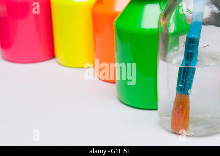 Pinsel in Wasser vor bunten Kinder Farbtöpfe für einen regnerischen Tagesaktivität Stockfoto