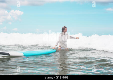 Mädchen auf den Wellen mit Surfbrett. Stockfoto