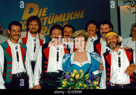 Sterben Sie Deutsche Fernsehansagerin Und Moderatorin Carolin Reiber Mit Dem Mooskirchner Quintett, Deutschland 1990er Jahre. Deutsche TV-Moderatorin Carolin Reiber, Deutschland der 1990er Jahre. Stockfoto