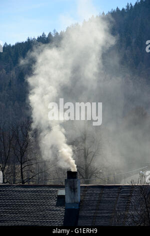 Rauch aus einem Schornstein des alten Hauses. Stockfoto