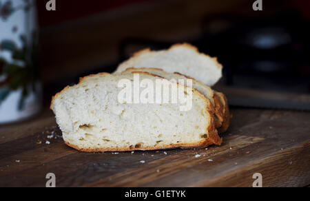 Weißes Brot auf Schneidbrett aus Holz mit Messer Stockfoto
