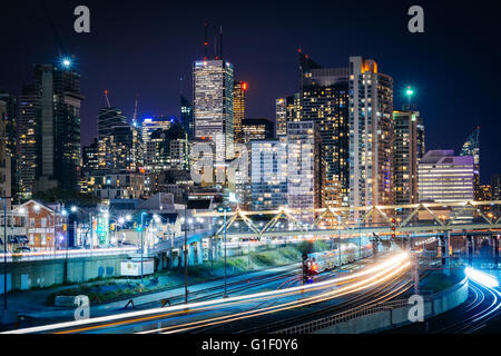 Blick auf Eisenbahnschienen und modernen Gebäuden in der Innenstadt in der Nacht, von der Bathurst Street Bridge in Toronto, Ontario. Stockfoto