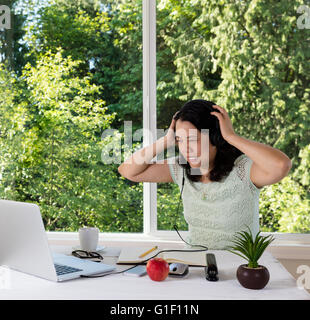 Reife Frau, mit dem Ausdruck ihrer Frustration, zu Hause arbeiten. Stockfoto