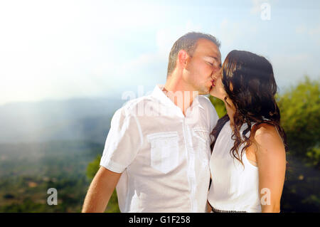 Junges Paar gekleidet in weißen liebevoll küssen in den Bergen einen sonnigen Tag Stockfoto