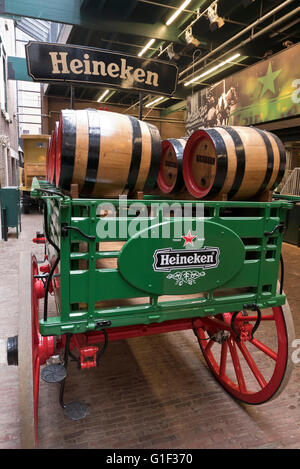 Ein Wagen mit einigen Heineken Fässer befindet sich durch die Ställe in der Heineken-Museum in Amsterdam, Holland, Niederlande. Stockfoto