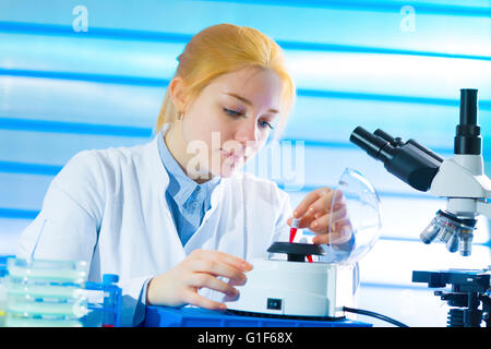 -MODELL VERÖFFENTLICHT. Weibliche Labor Techniker halten Probe im Labor. Stockfoto