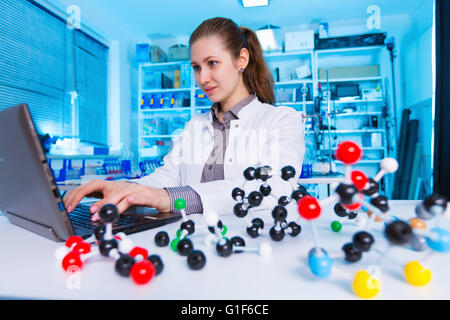 -MODELL VERÖFFENTLICHT. Weiblichen Chemiker mit Laptop im Labor. Stockfoto