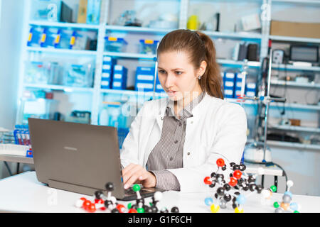 -MODELL VERÖFFENTLICHT. Wissenschaftlerin mit Laptop im Labor. Stockfoto