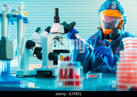 -MODELL VERÖFFENTLICHT. Person, tragen von Schutzkleidung in einem mikrobiologischen Labor arbeiten. Stockfoto