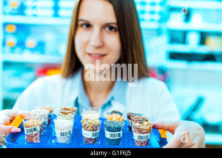 -MODELL VERÖFFENTLICHT. Weibliche Laborantin mit Lebensmittelproben für Allergie-Tests im Labor. Stockfoto