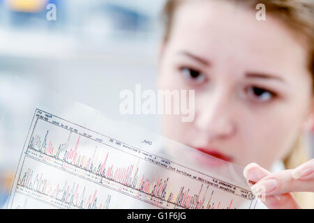 -MODELL VERÖFFENTLICHT. Wissenschaftlerin, die DNA-Sequenzierung Ergebnisse halten. Stockfoto