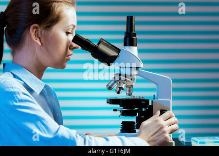 -MODELL VERÖFFENTLICHT. Wissenschaftlerin mit einem Mikroskop. Stockfoto