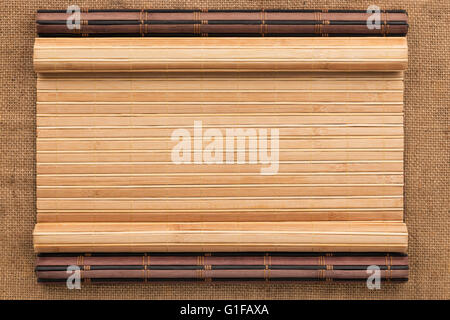 Zwei Bambusmatte verdreht in Form eines Manuskripts auf Sackleinen, mit Platz für Ihren text Stockfoto