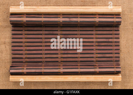 Zwei Bambusmatte verdreht in Form eines Manuskripts auf Sackleinen, mit Platz für Ihren text Stockfoto