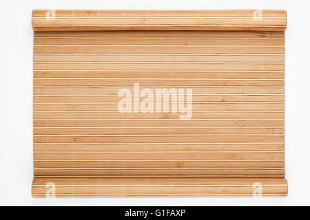 Bambusmatte verdreht in Form eines Manuskripts auf weißem Hintergrund Stockfoto